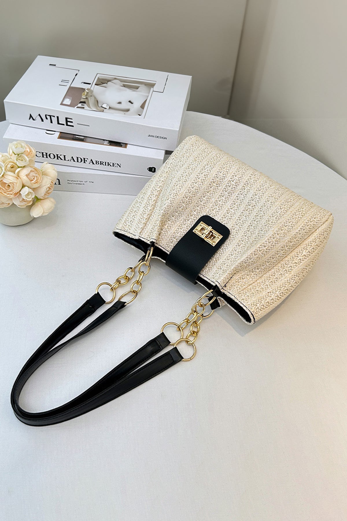 Bolso tote negro de piel sintética con textura tejida y asa de cadena