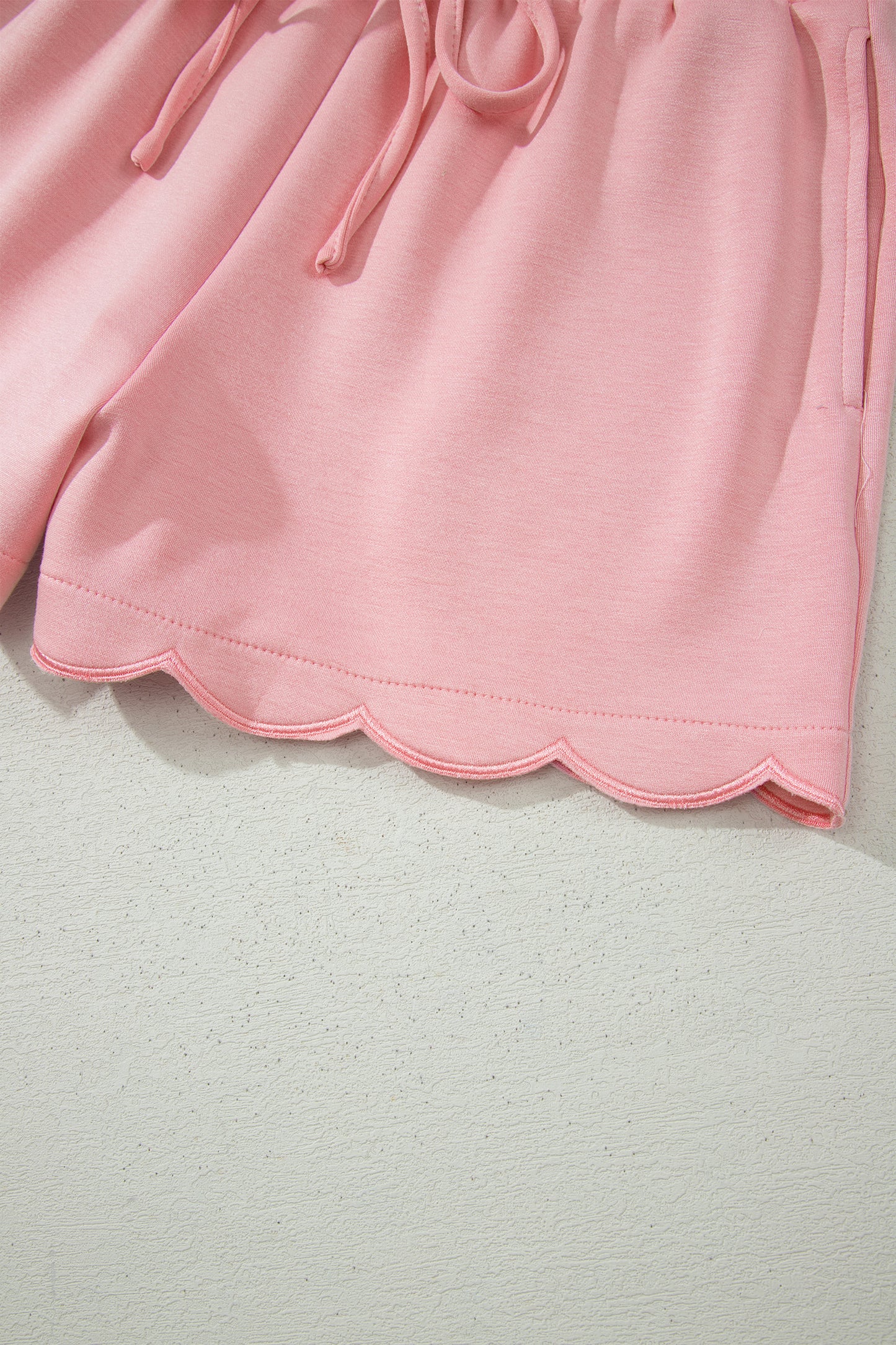 Conjunto de top tipo dolman oversize rosa con cuello en V festoneado y cordón ajustable