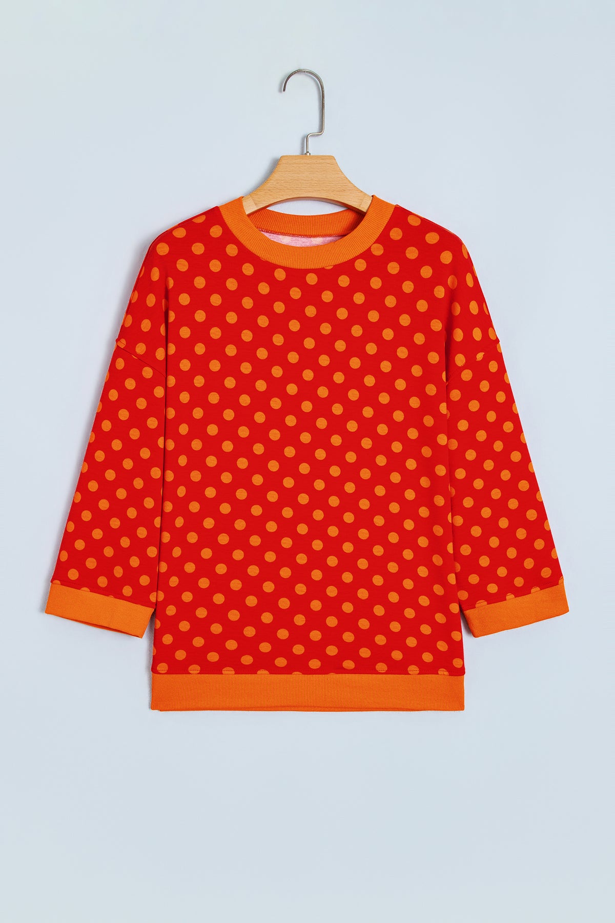 Top de cuello redondo con mangas tres cuartos, estampado de lunares marrones y ribete en contraste.