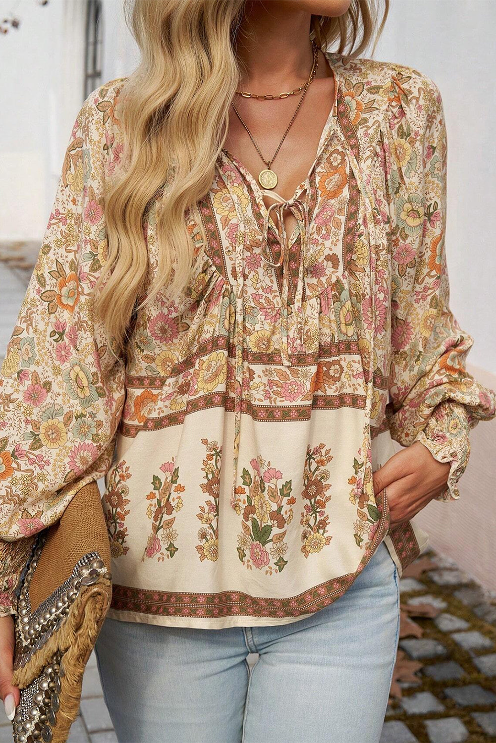 Blusa amarilla con estampado floral, cuello anudado y mangas farol