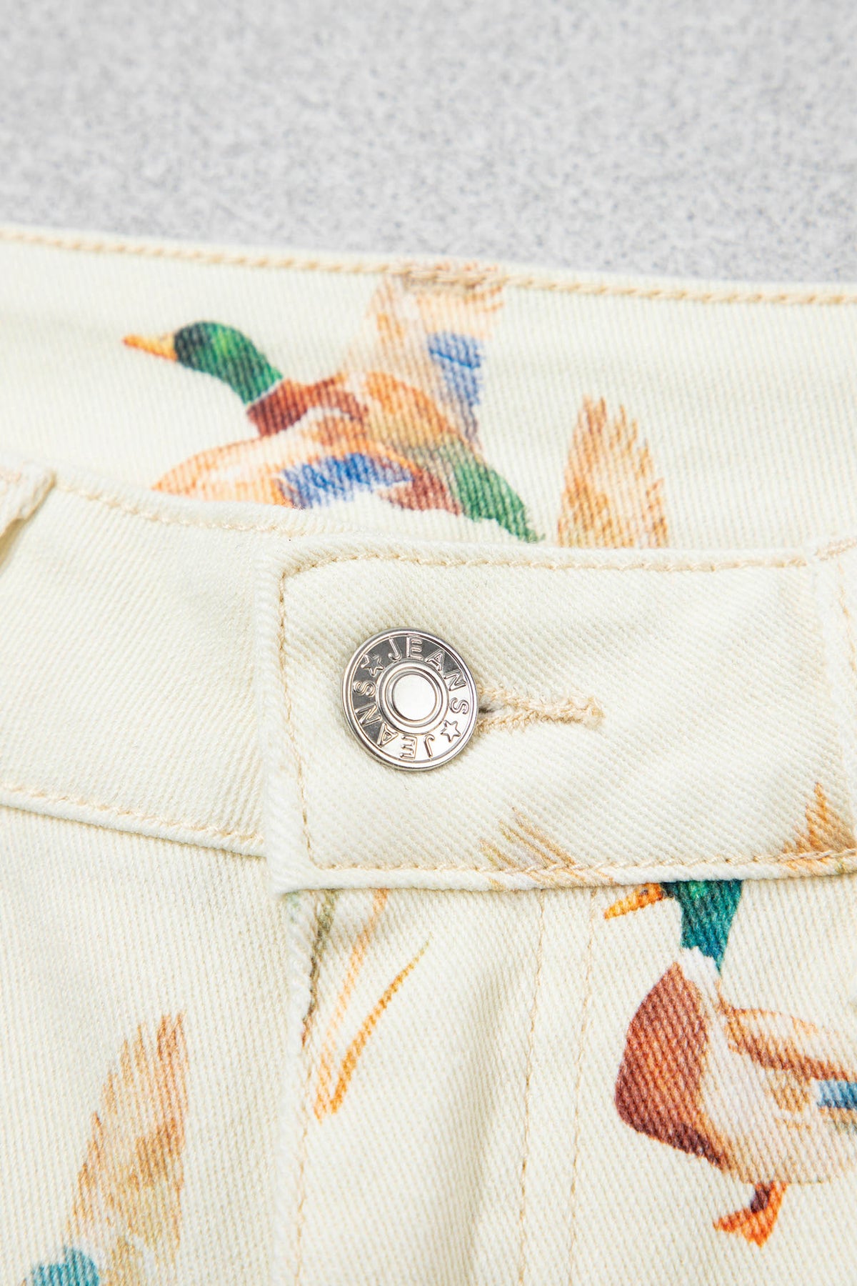 Vaqueros beige elegantes con estampado de patos y bajo con puños