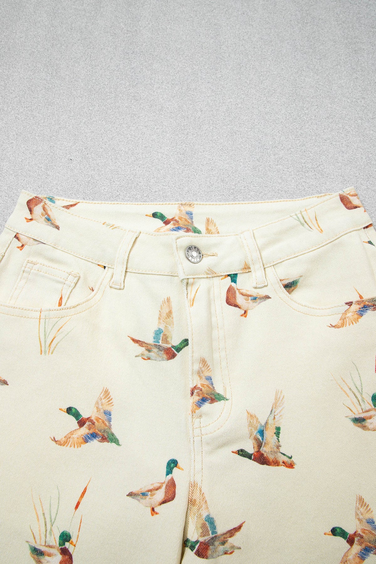 Vaqueros beige elegantes con estampado de patos y bajo con puños