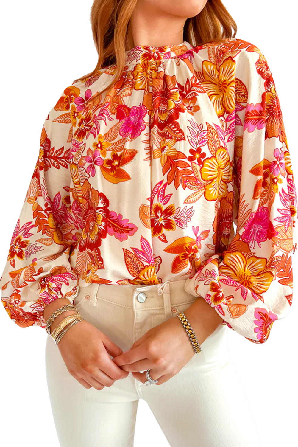 Blusa naranja con estampado floral, botones de perla, abertura tipo lágrima y manga larga abullonada.