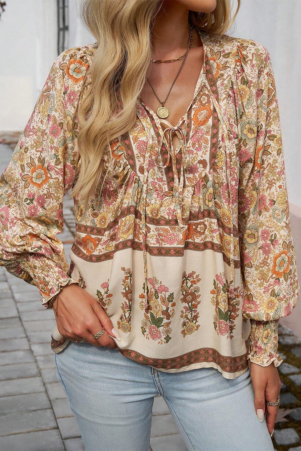 Blusa amarilla con estampado floral, cuello anudado y mangas farol