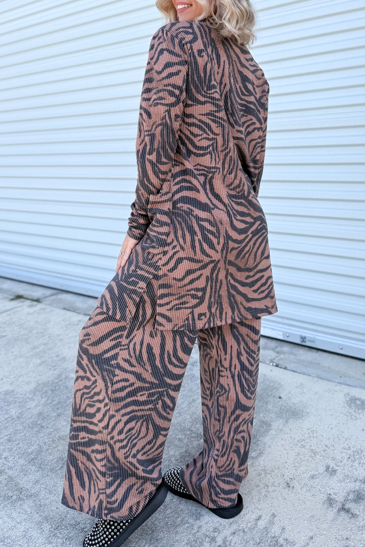 Conjunto de cárdigan abierto y pantalón de pierna ancha en color caqui, con estampado de cebra y textura acanalada retorcida.