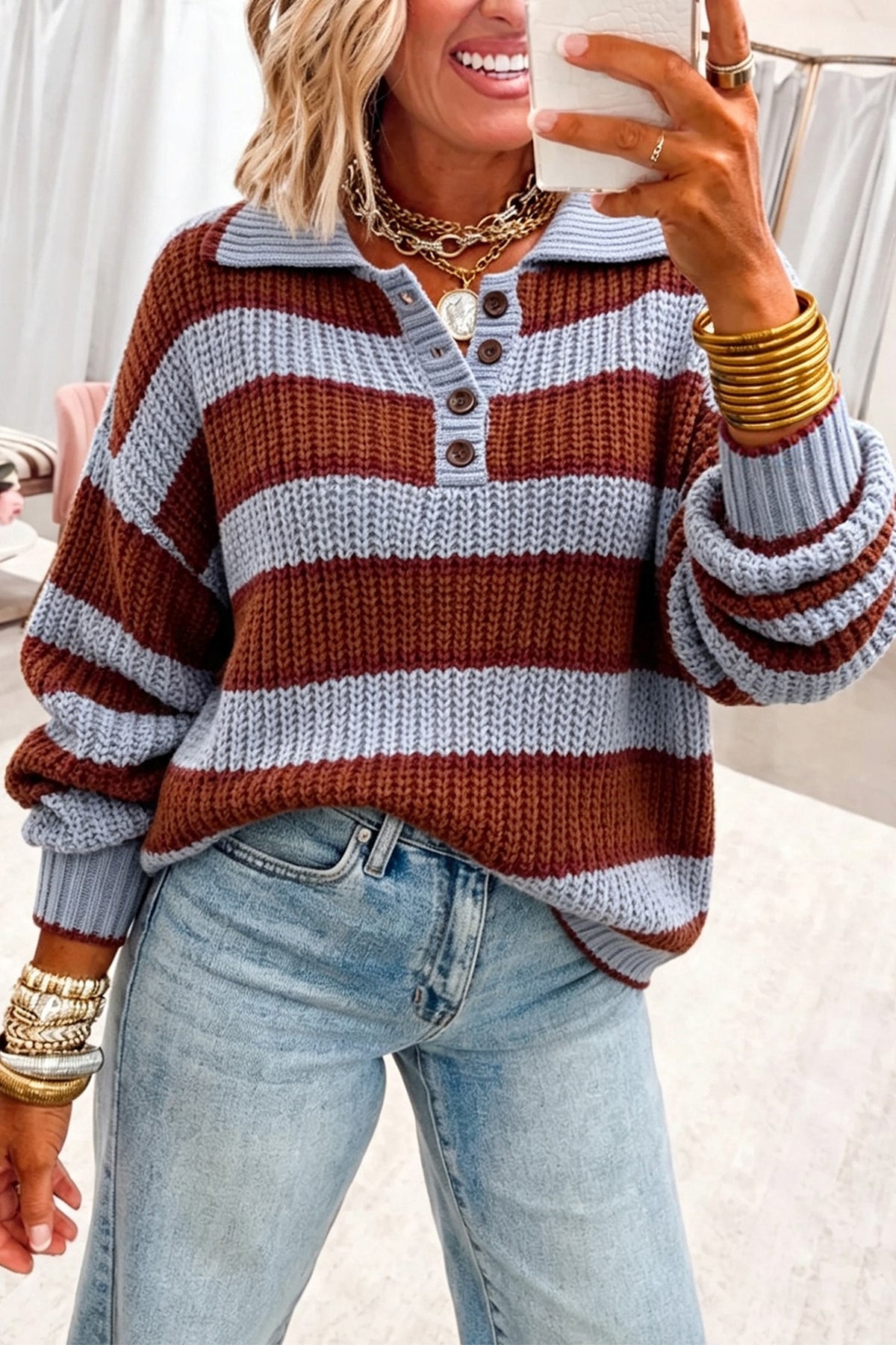 Suéter tipo pulóver holgado, color rojo dalia, con cuello abotonado y hombros caídos.