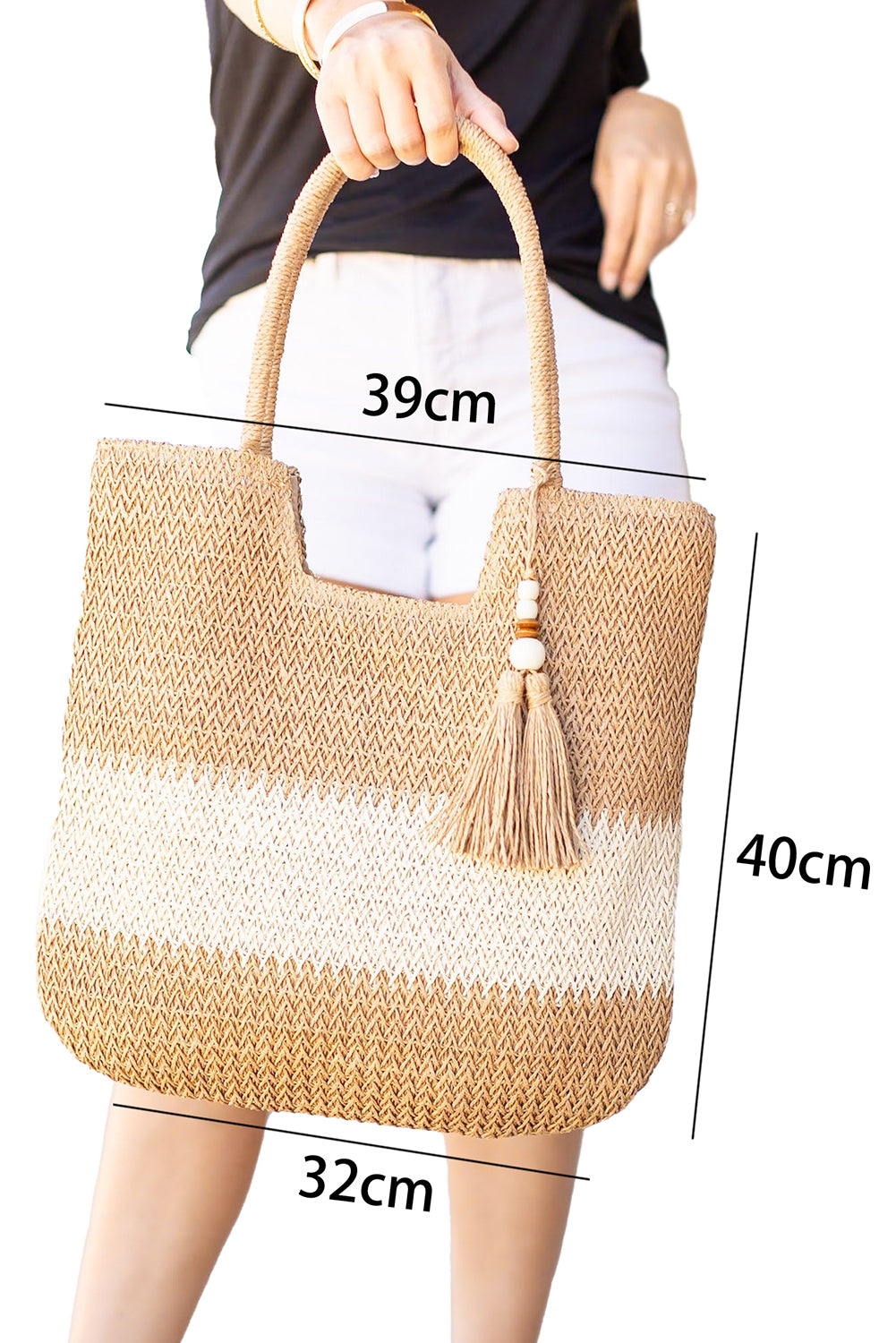 Bolso tote de paja trenzada en color castaño con diseño de bloques de color y detalle de borlas.