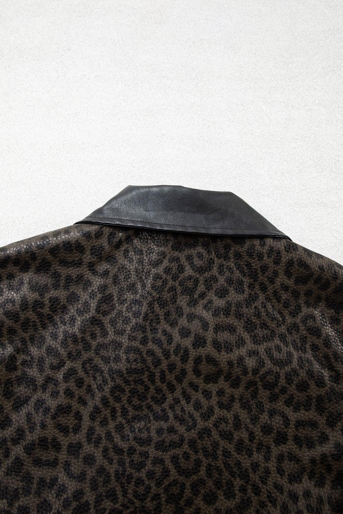 Chaqueta multicolor con estampado de leopardo, diseño en bloques de color, cuello y cierre frontal metálico.