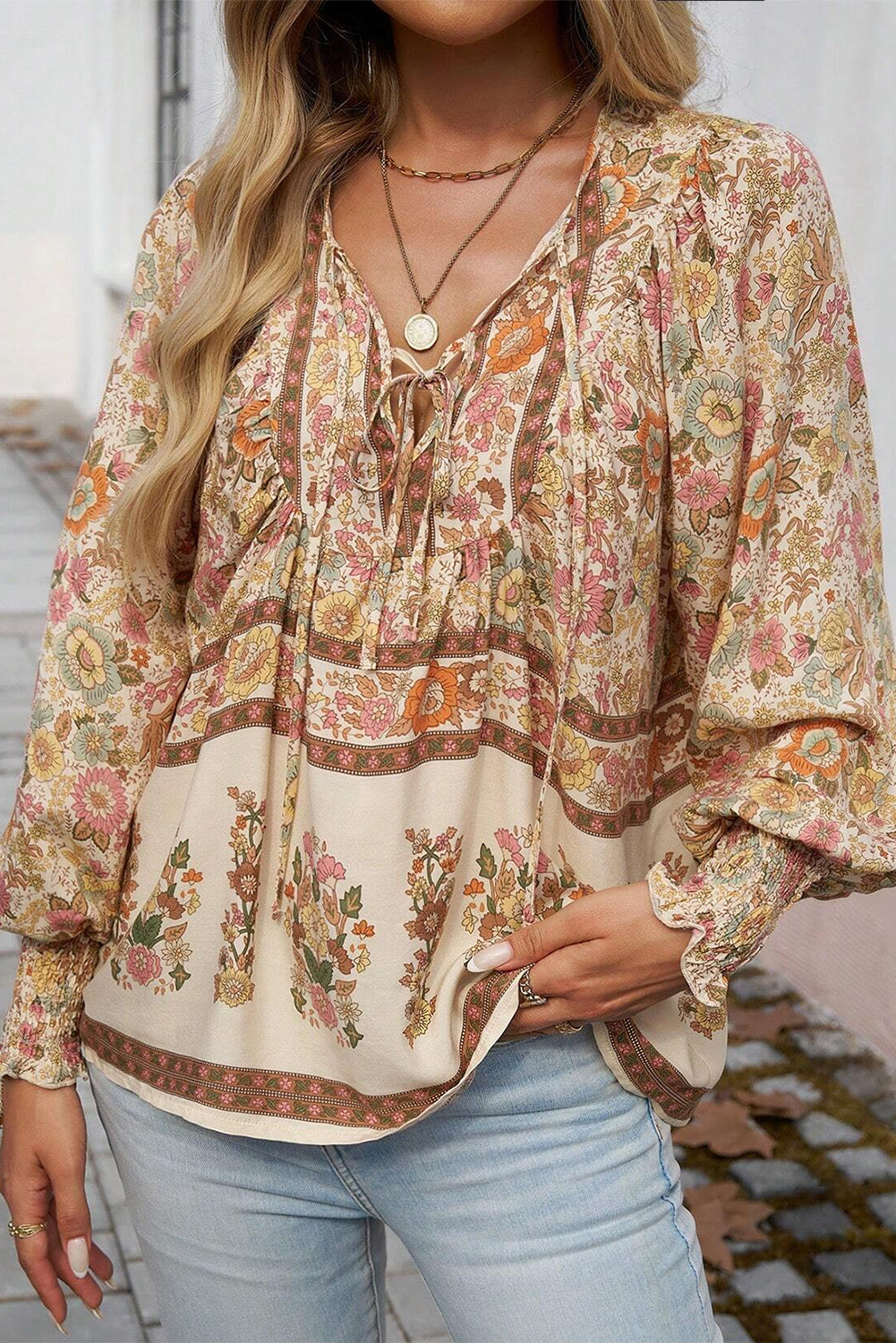 Blusa amarilla con estampado floral, cuello anudado y mangas farol