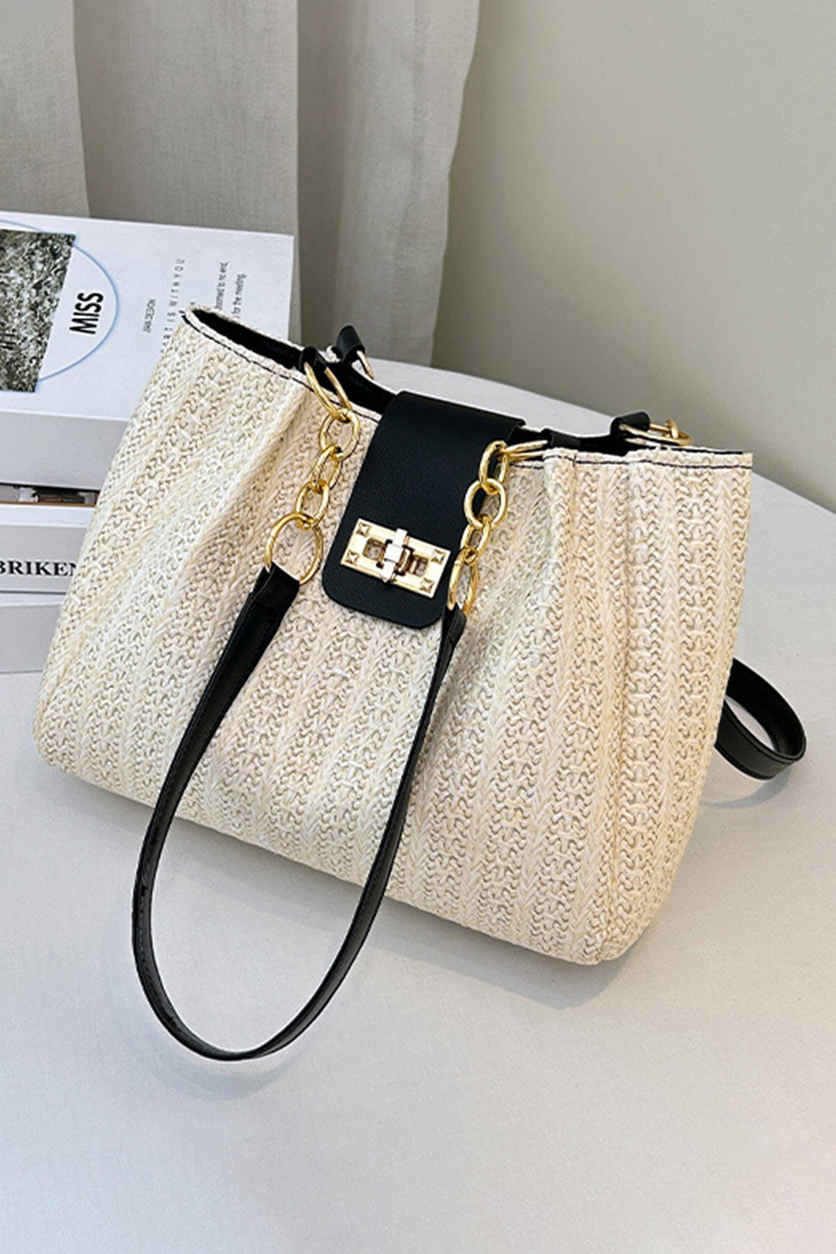 Bolso tote negro de piel sintética con textura tejida y asa de cadena
