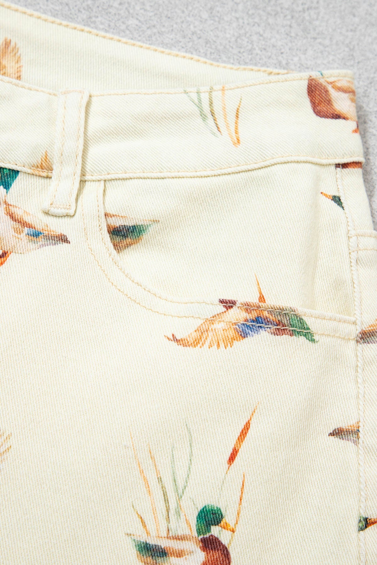 Vaqueros beige elegantes con estampado de patos y bajo con puños