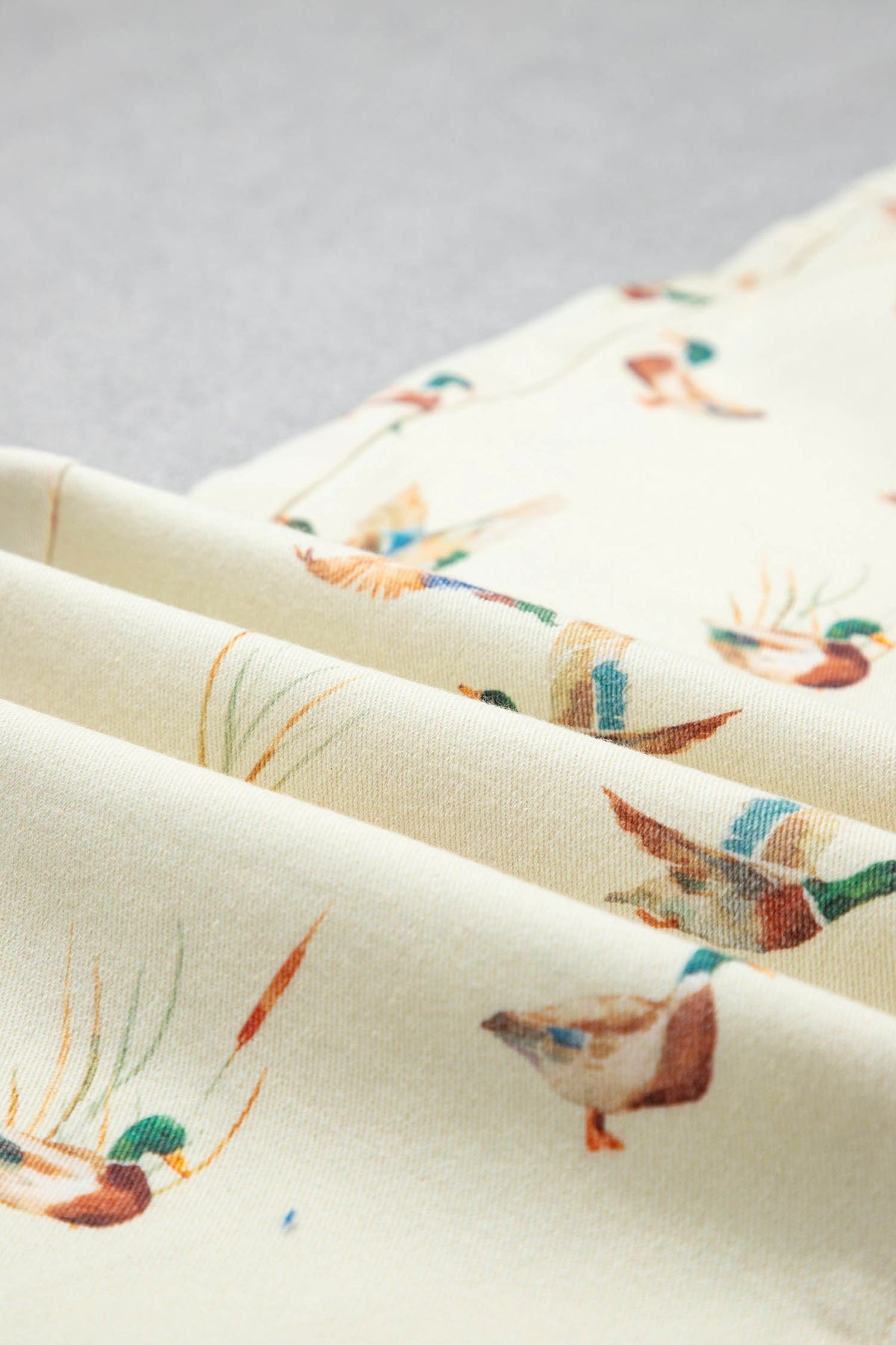 Vaqueros beige elegantes con estampado de patos y bajo con puños