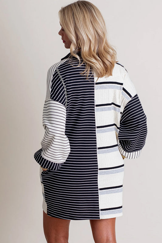 Minivestido de corte recto y manga larga con diseño de bloques de color y rayas negras, cuello Henley y tejido de punto.