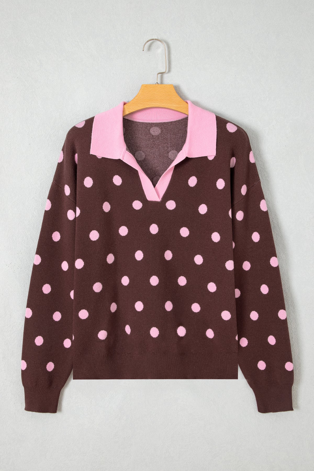 Suéter tipo pulóver holgado con cuello, diseño de bloques de color y estampado de lunares rosas.