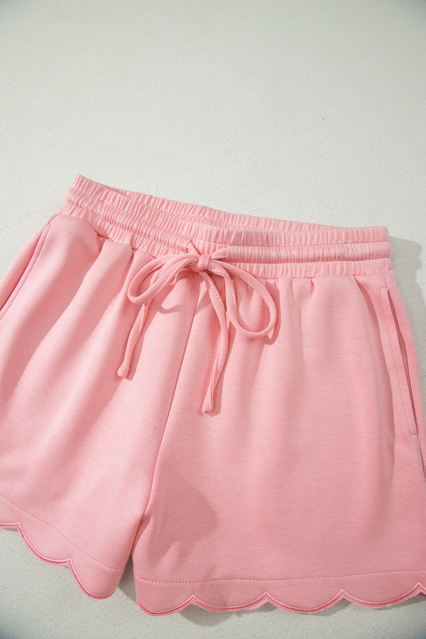 Conjunto de top tipo dolman oversize rosa con cuello en V festoneado y cordón ajustable