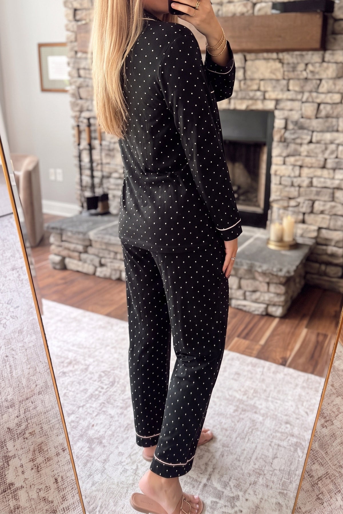 Conjunto de pijama de dos piezas: camisa de manga larga negra con lunares y detalles de encaje, y pantalón.