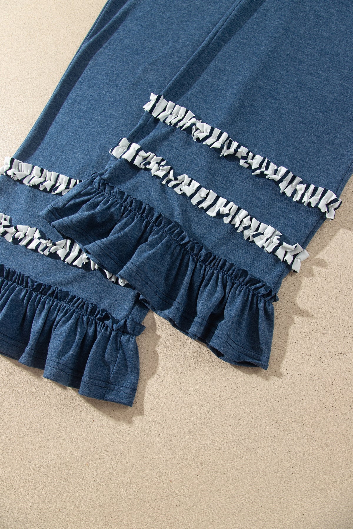 Conjunto de 2 piezas: top de rayas azules con cuello en V y mangas con volantes en contraste, y pantalón con cordón ajustable.
