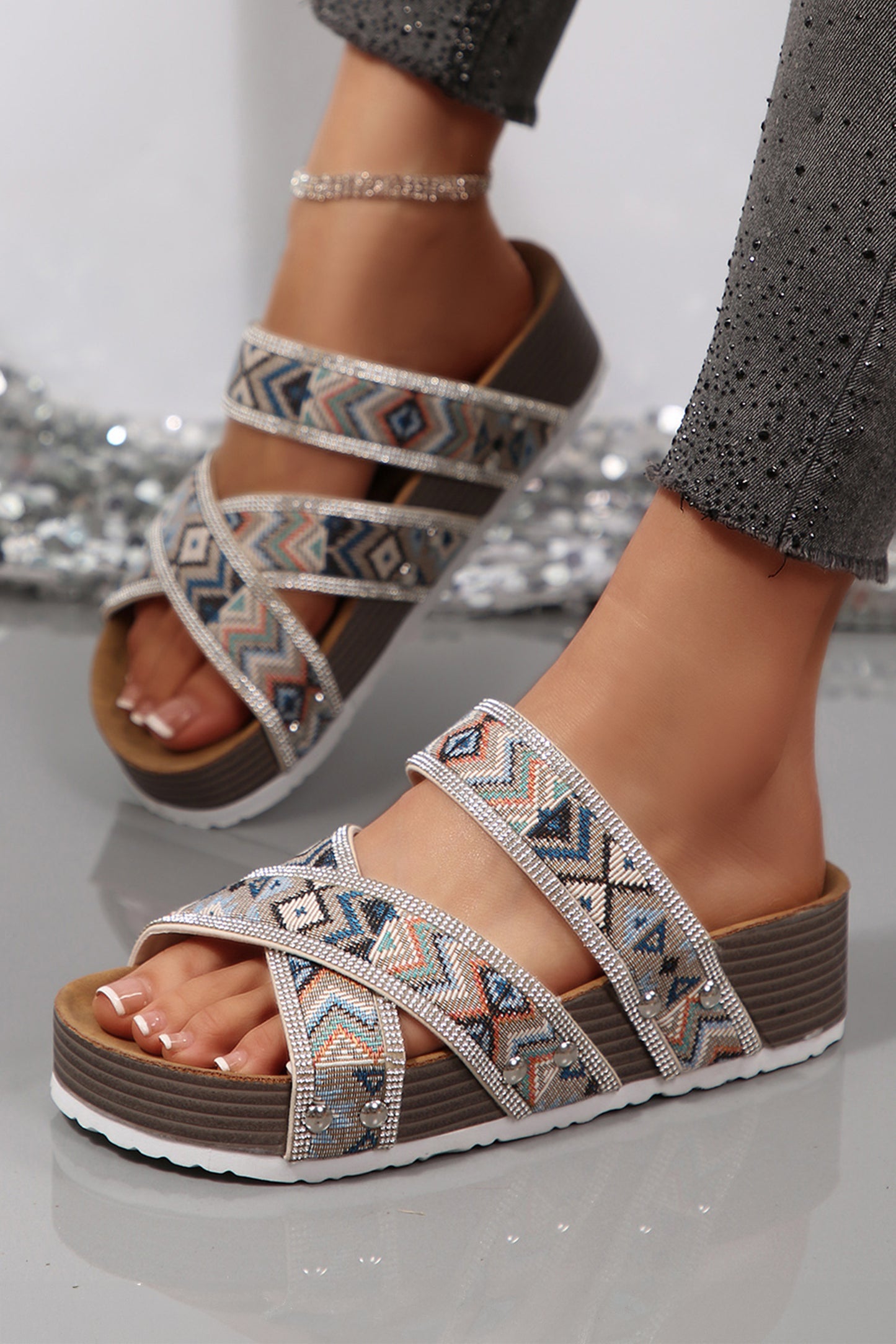 Sandalias de plataforma negras con diseño tribal geométrico, adornos de pedrería, tiras y aberturas.