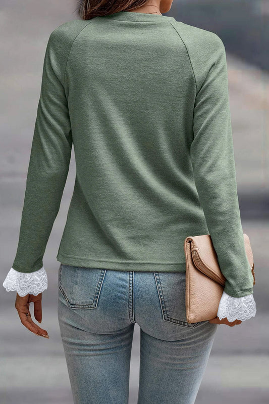 Top de manga raglán con detalle de costura en verde hierba, puños de encaje en contraste y mangas raglán.