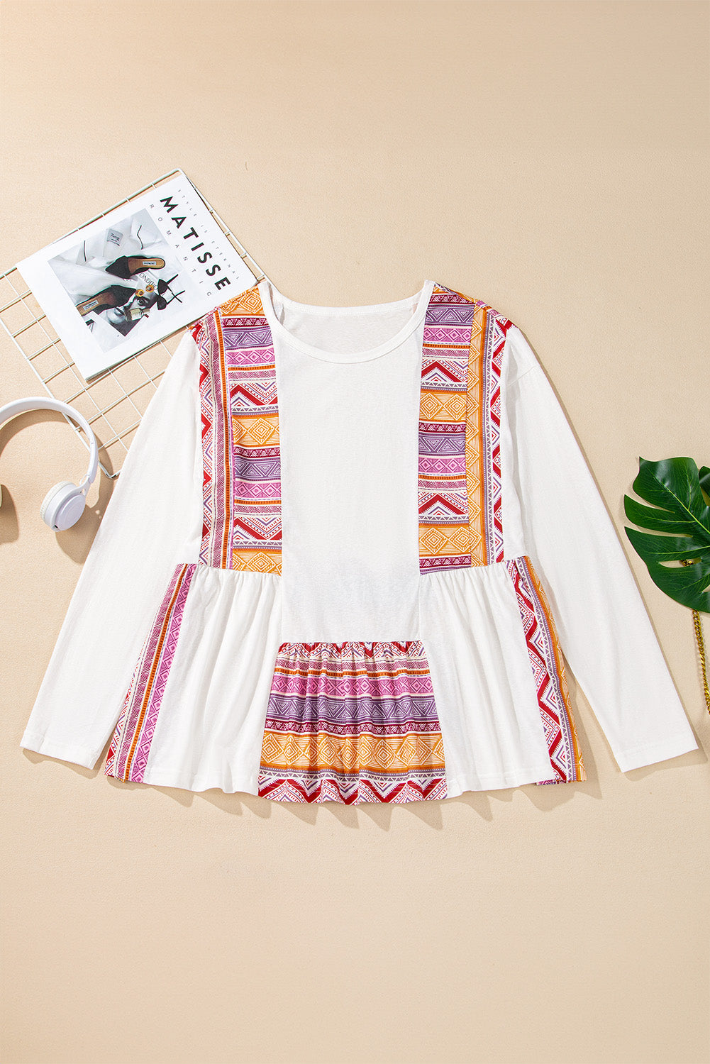 Blusa tipo túnica blanca de manga larga, corte babydoll y estilo occidental, con diseño de retazos (patchwork), estampado azteca y volantes.