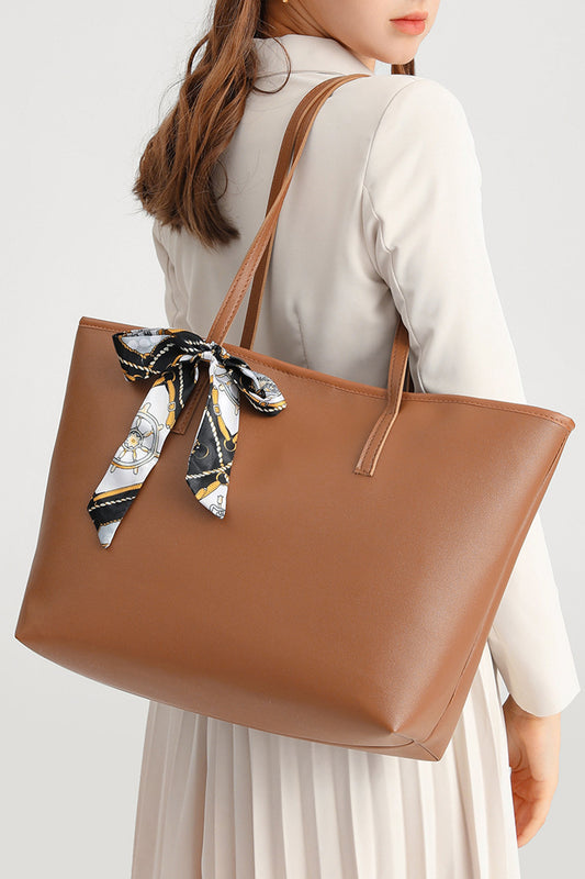 Bolso de piel sintética color castaño, de gran capacidad y con detalle de lazo.
