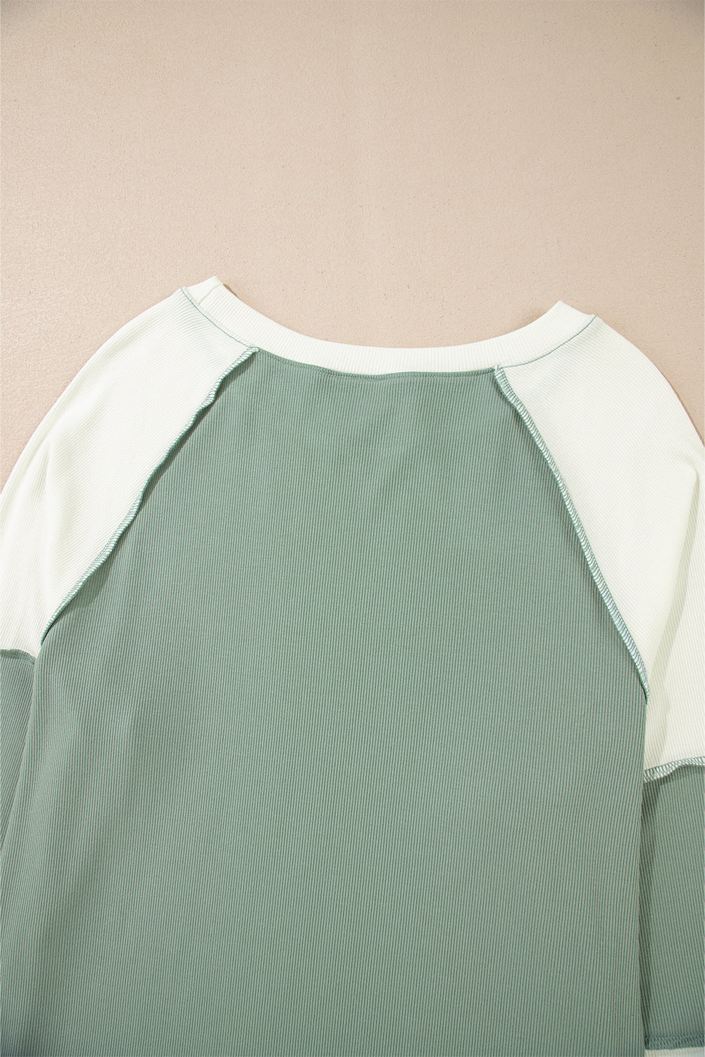 Top de manga larga raglán con diseño de bloques de color, estilo patchwork y textura acanalada, en verde menta.