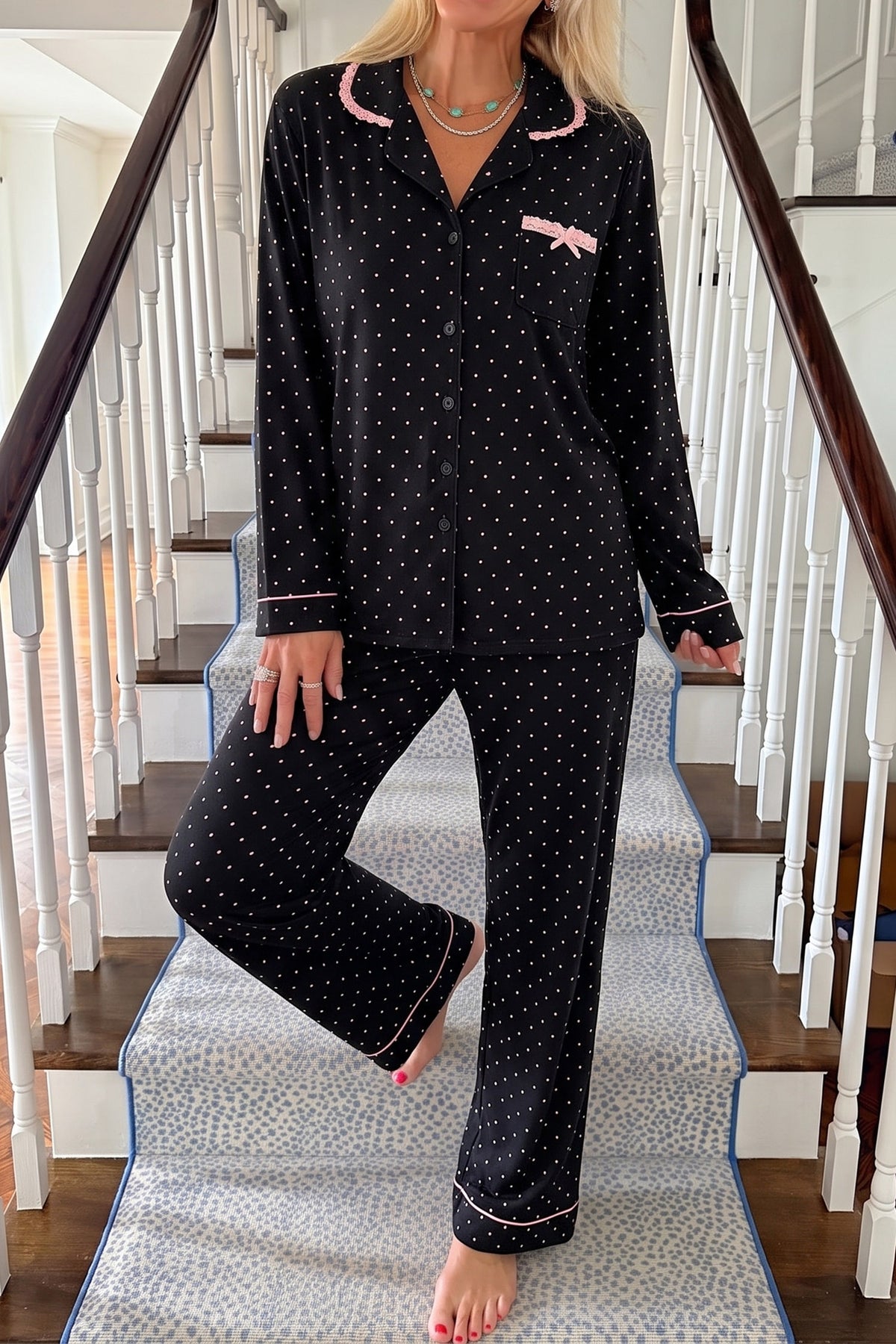 Conjunto de pijama de dos piezas: camisa de manga larga negra con lunares y detalles de encaje, y pantalón.
