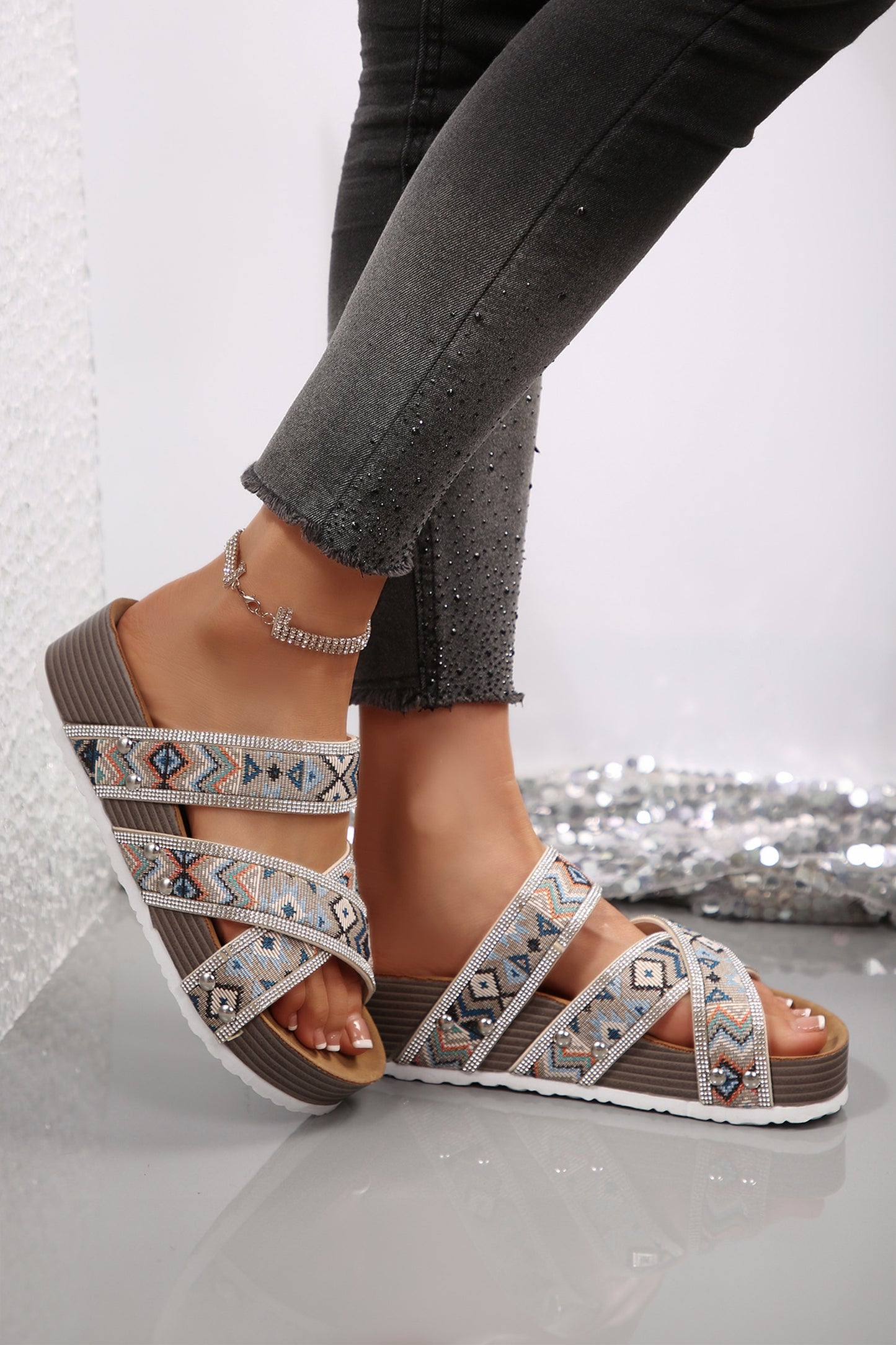 Sandalias de plataforma negras con diseño tribal geométrico, adornos de pedrería, tiras y aberturas.