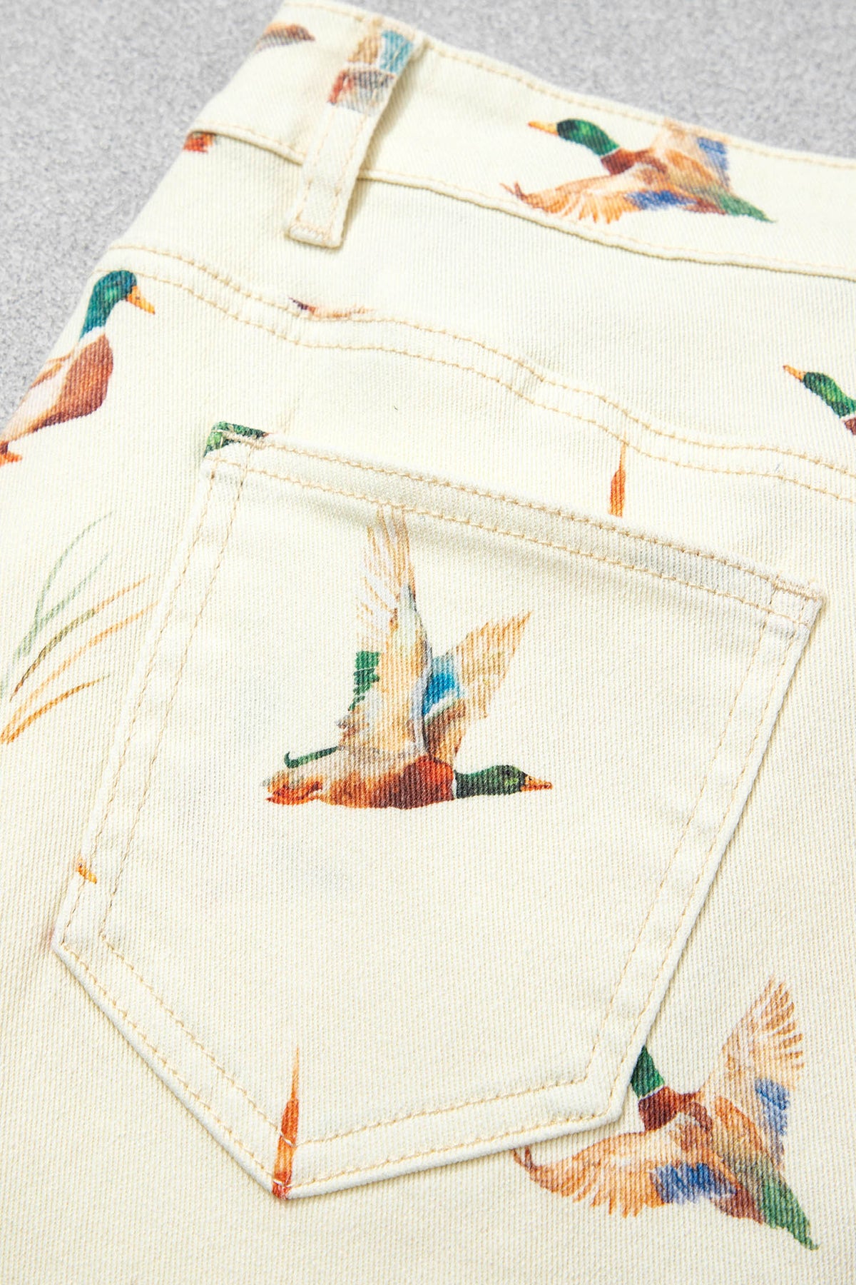 Vaqueros beige elegantes con estampado de patos y bajo con puños