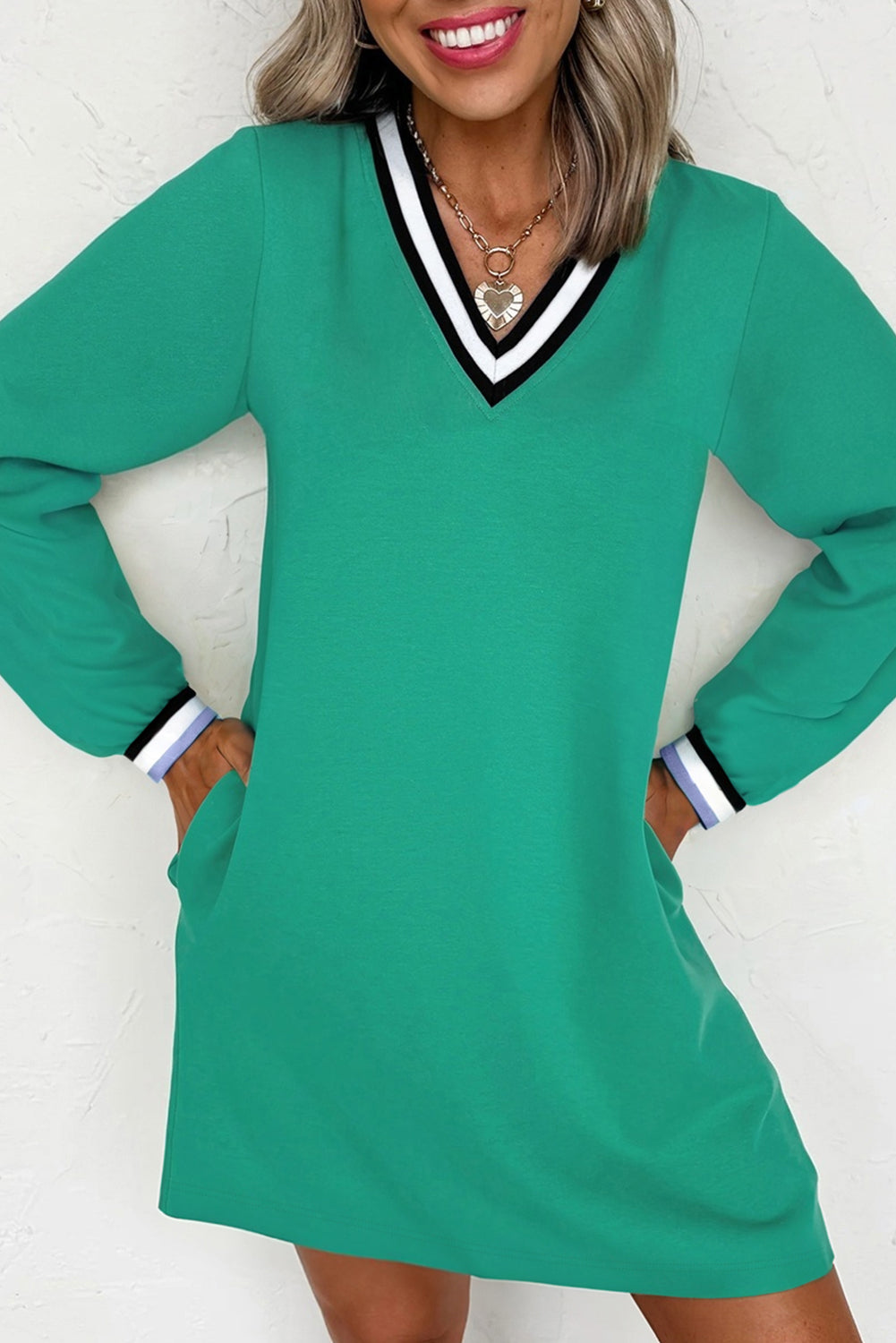 Vestido tipo camiseta de manga larga y cuello en V, color verde menta, estilo universitario con rayas en contraste y bolsillos.
