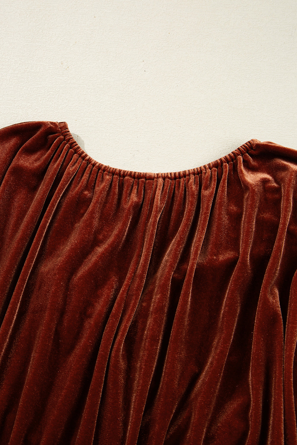 Vestido corto de terciopelo color arcilla con cuello en V, mangas abullonadas y diseño elástico.