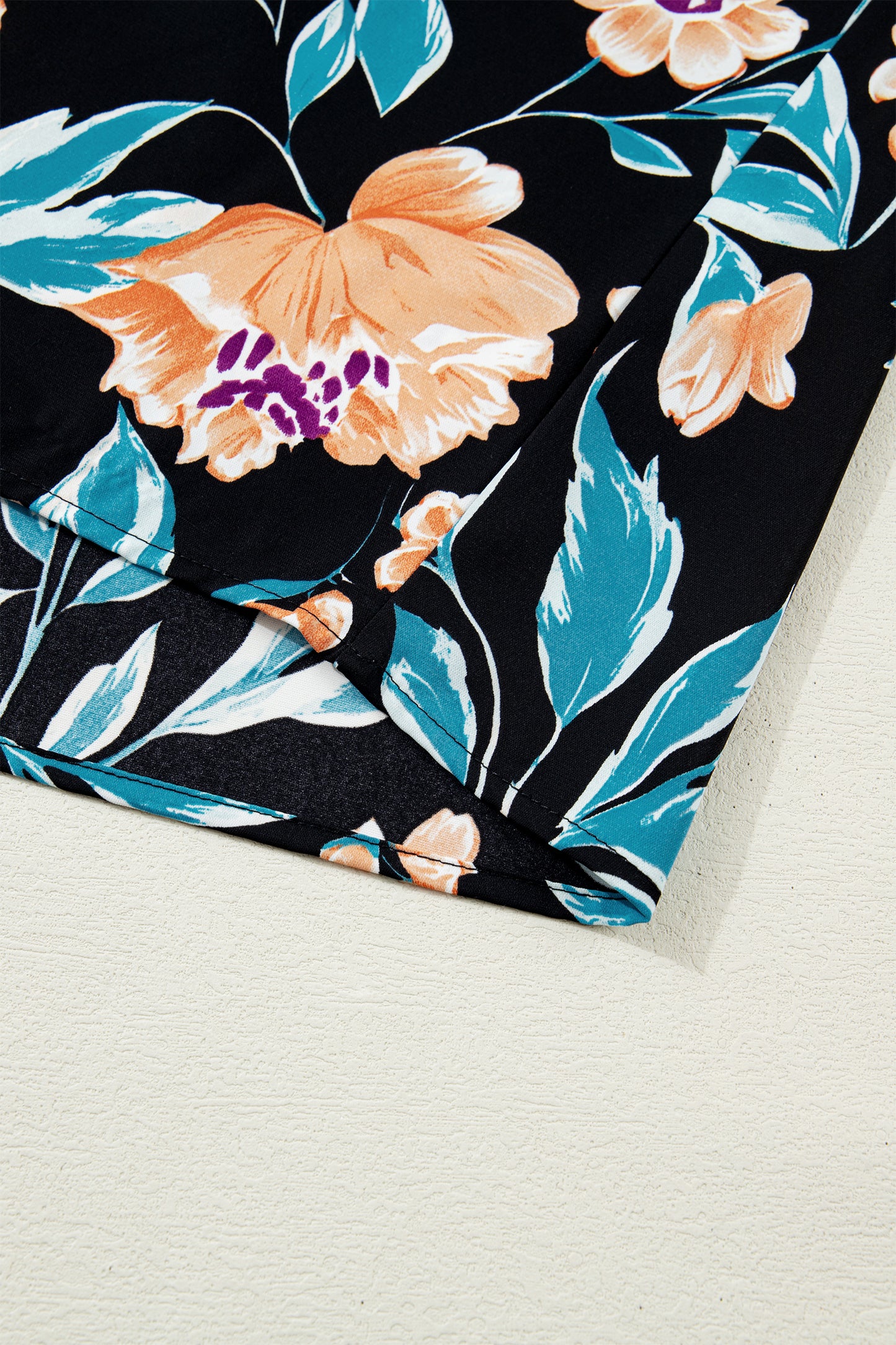 Blusa negra con estampado floral, mangas cortas abullonadas, botones y cuello con muesca