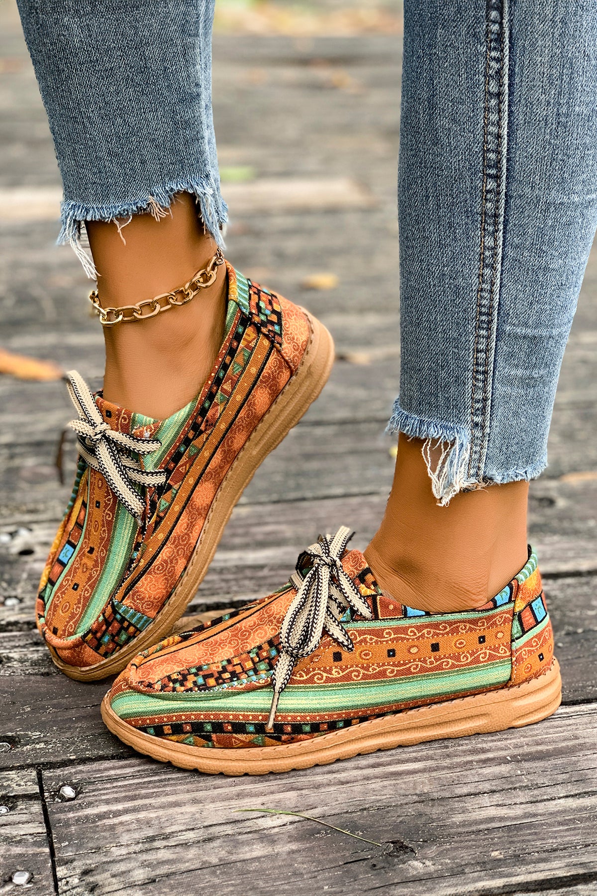 Mocasines cómodos color mostaza con estampado artístico de estilo étnico y detalle de cordones.