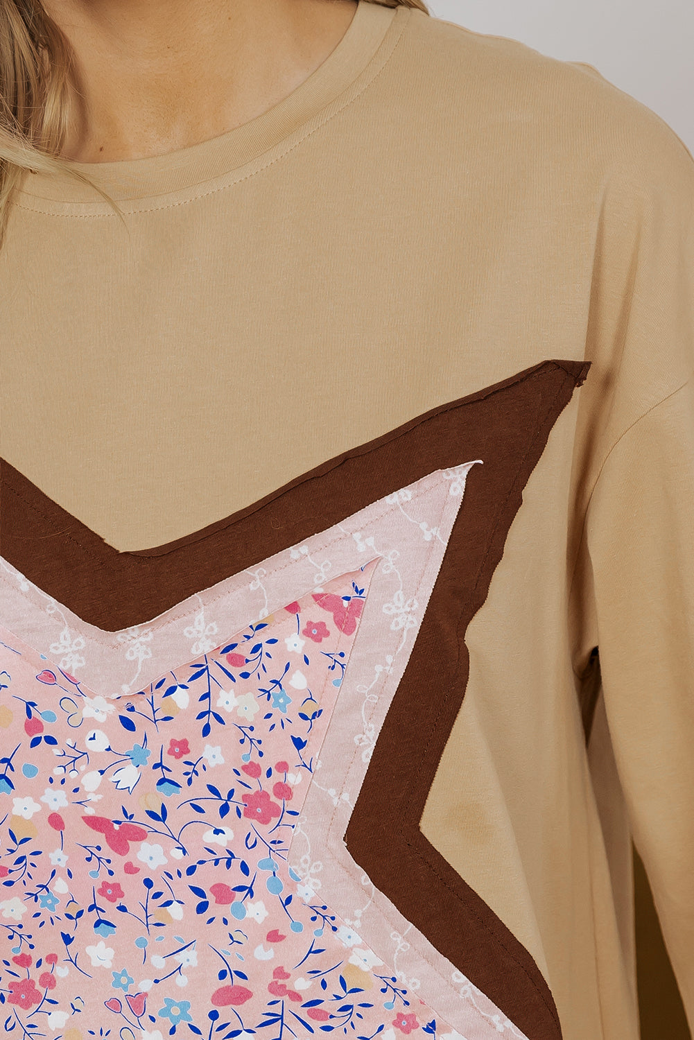 Top de manga tres cuartos con estampado floral y diseño de parches tipo estrella en color camel