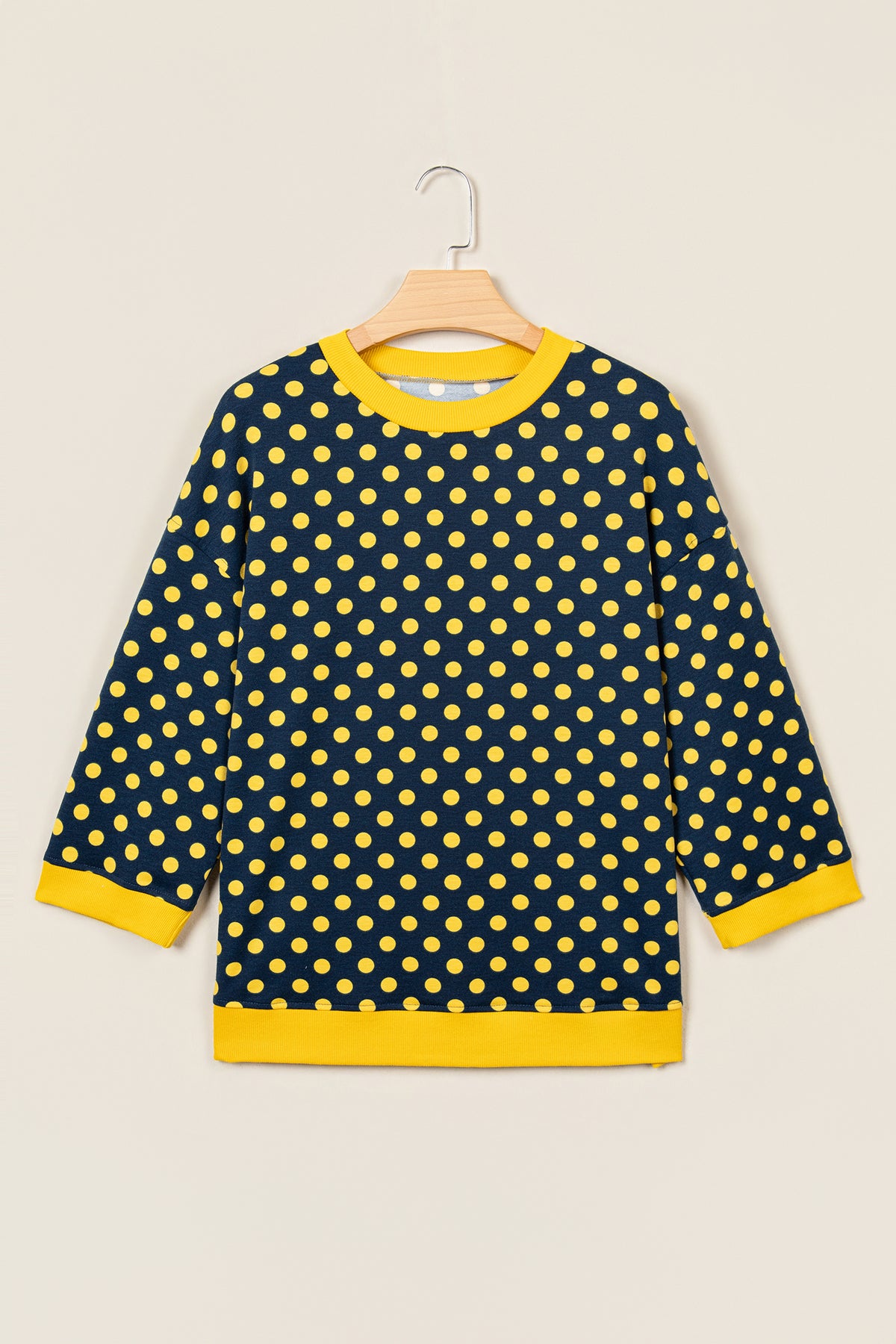 Top de cuello redondo con mangas tres cuartos, estampado de lunares marrones y ribete en contraste.