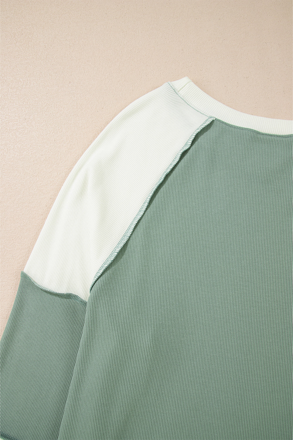 Top de manga larga raglán con diseño de bloques de color, estilo patchwork y textura acanalada, en verde menta.