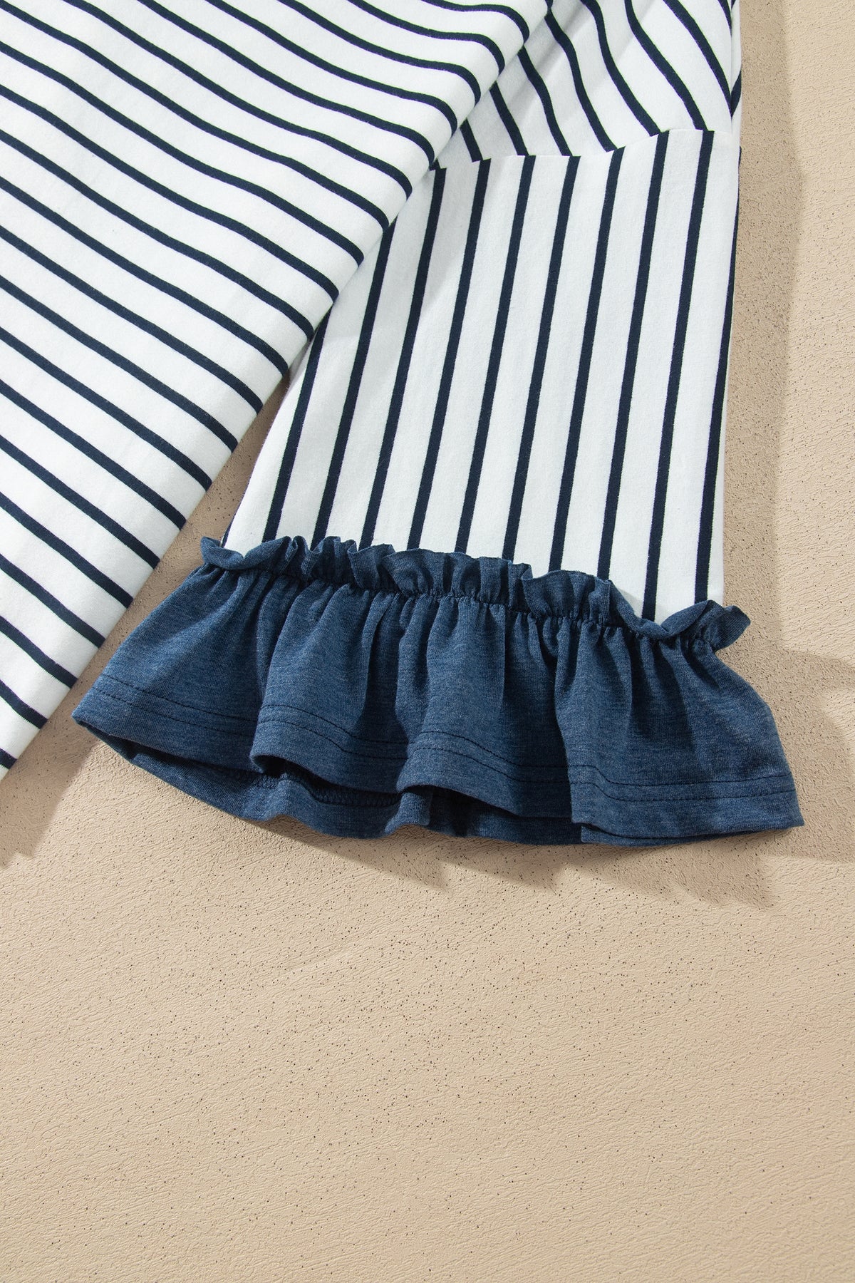 Conjunto de 2 piezas: top de rayas azules con cuello en V y mangas con volantes en contraste, y pantalón con cordón ajustable.