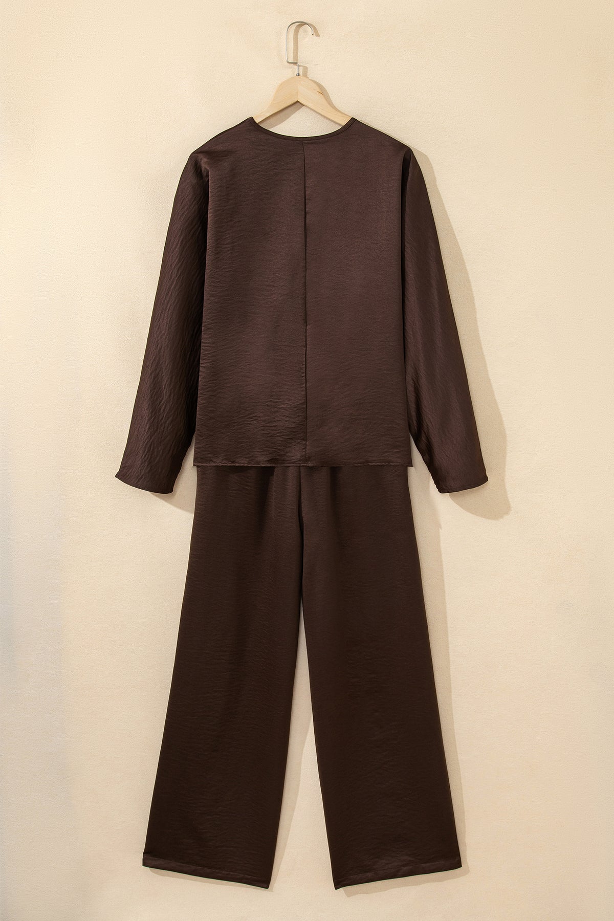 Conjunto de 2 piezas: blusa holgada de manga larga con cuello en V y detalle trenzado, y pantalón de tiro alto con cordón, en color marrón oscuro.