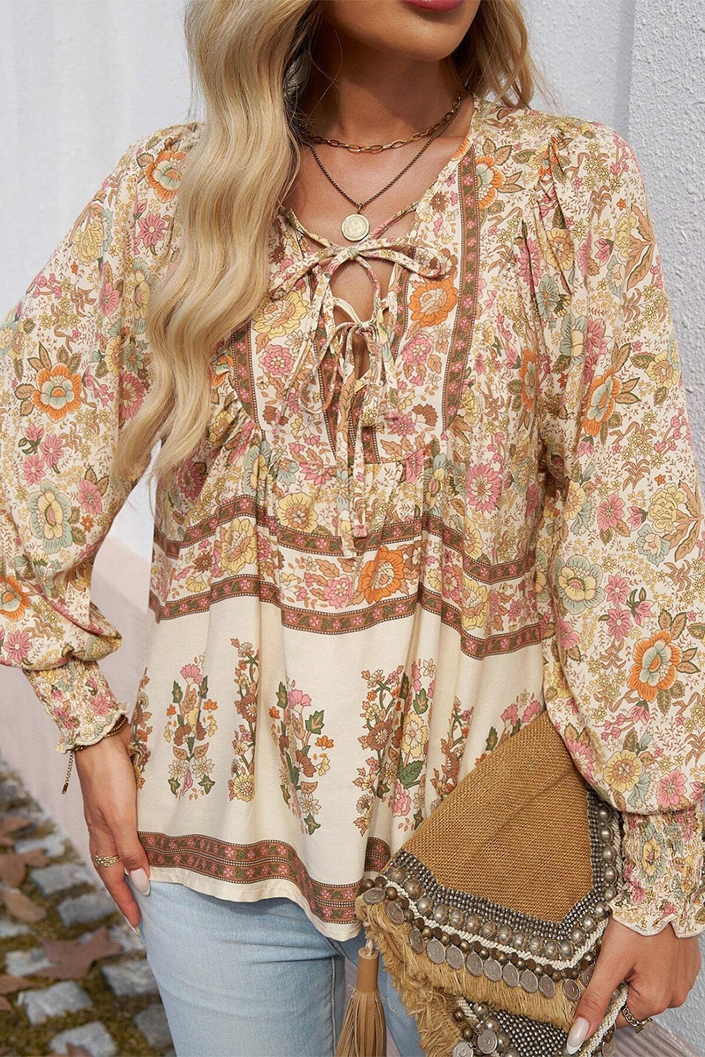 Blusa amarilla con estampado floral, cuello anudado y mangas farol