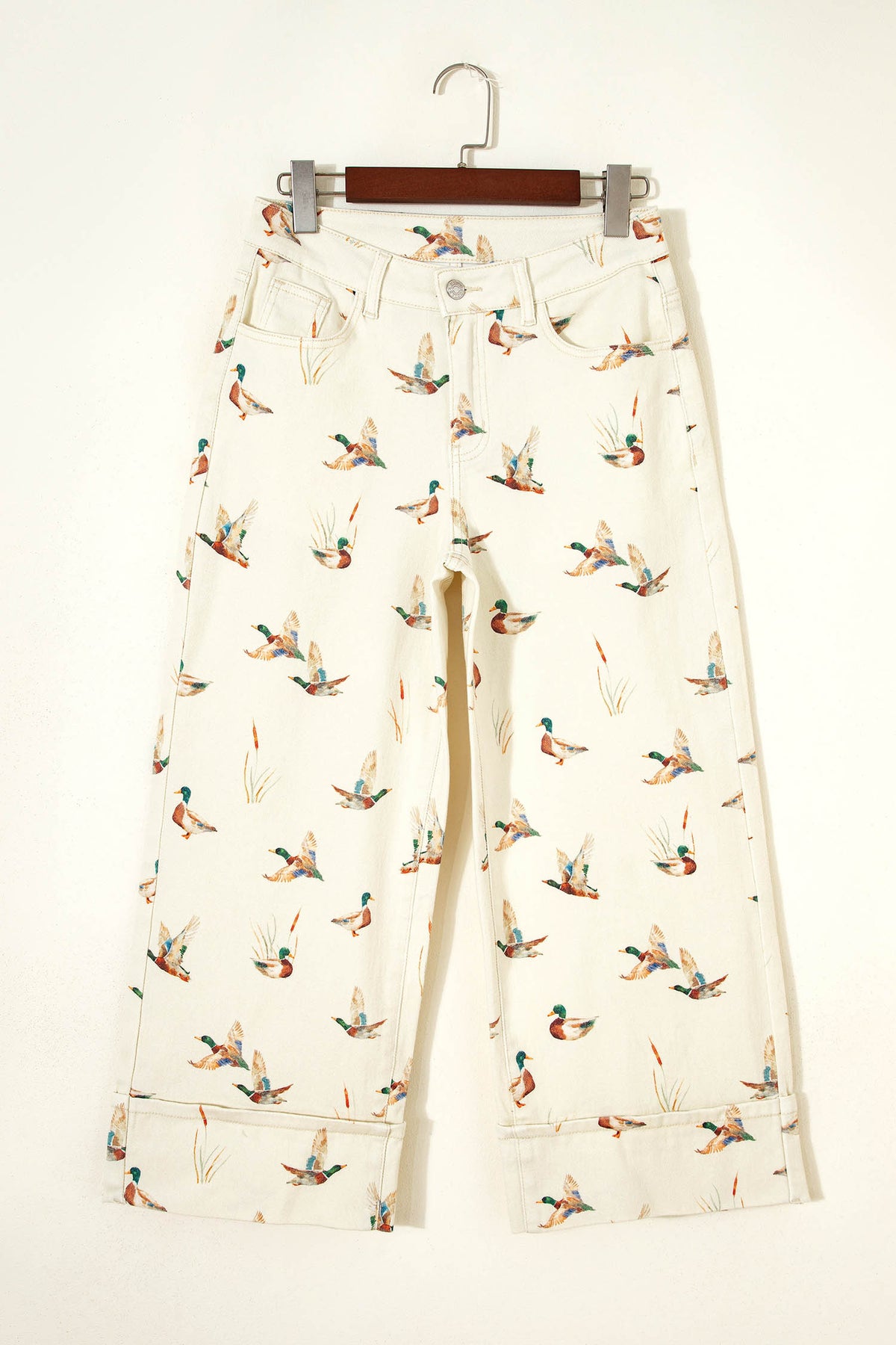 Vaqueros beige elegantes con estampado de patos y bajo con puños